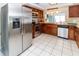 Spacious kitchen with stainless steel appliances, wood cabinets, and white tile floors at 3526 Overland Dr, Holiday, FL 34691