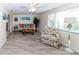 Bright living room featuring wood floors, comfortable seating, a ceiling fan and lots of natural light at 3526 Overland Dr, Holiday, FL 34691