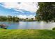 Scenic view of a tranquil lake surrounded by lush greenery and neighboring houses under a cloudy sky at 3526 Overland Dr, Holiday, FL 34691