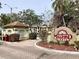 Welcoming entrance to Millpond Lakes, featuring brick accents, lush landscaping, and a charming guard house at 4529 Whitton Way # 214, New Port Richey, FL 34653
