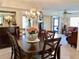 Dining room with large wood table, chandelier and view into adjacent living area at 4529 Whitton Way # 214, New Port Richey, FL 34653