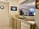 Cozy kitchen with white appliances and view into dining area with decorative chandelier lighting fixture at 4529 Whitton Way # 214, New Port Richey, FL 34653