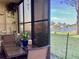 Lanai featuring patio table and chairs, shelving for plants and decor, and a view of the lake at 4529 Whitton Way # 214, New Port Richey, FL 34653