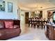 Open-concept living and dining area features tiled floors and elegant chandelier, offering a spacious and inviting atmosphere at 4529 Whitton Way # 214, New Port Richey, FL 34653