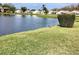Picturesque view of a calm pond and lush green lawn showing a serene setting with residential buildings in the distance at 4529 Whitton Way # 214, New Port Richey, FL 34653