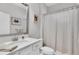 Inviting bathroom showcasing white cabinets, shower with a curtain, a mirror and calming wall decor at 4778 Ballantrae Blvd, Land O Lakes, FL 34638