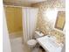 Cozy bathroom featuring floral wallpaper, white fixtures and a shower with curtain at 4801 Airport Rd # 208, Zephyrhills, FL 33542