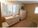 Cozy bedroom with white dressers, shuttered windows and neutral walls and carpet at 4801 Airport Rd # 208, Zephyrhills, FL 33542