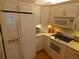 Well-lit kitchen featuring white appliances, ample cabinet space, and a modern oven range at 4801 Airport Rd # 208, Zephyrhills, FL 33542