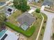Aerial view of a well-maintained home featuring a screened-in pool and lush, manicured landscaping at 6112 Kinlock Ave, Spring Hill, FL 34608
