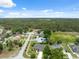 Single-story home from above, located on a street with sidewalks near a green field and wooded area at 6112 Kinlock Ave, Spring Hill, FL 34608