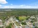 Aerial view of a single-story home in a serene neighborhood, backing onto a sprawling forest with a picturesque landscape at 6112 Kinlock Ave, Spring Hill, FL 34608