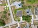 Back aerial view of a single-story home with a screened in pool and long privacy hedge on a street with sidewalks at 6112 Kinlock Ave, Spring Hill, FL 34608