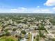 Wide aerial view of a vibrant suburban community with lush green spaces and a variety of houses under a clear sky at 6112 Kinlock Ave, Spring Hill, FL 34608