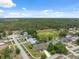 Aerial view showcasing a single-story home nestled in a tranquil neighborhood, backing onto a verdant expanse of forest at 6112 Kinlock Ave, Spring Hill, FL 34608