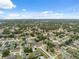 Expansive aerial view of a densely populated residential area with abundant trees and varied home styles on a sunny day at 6112 Kinlock Ave, Spring Hill, FL 34608