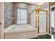 Bathroom featuring a soaking tub, tiled flooring, wallpaper, and a separate glass shower at 6112 Kinlock Ave, Spring Hill, FL 34608