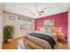 Bright bedroom boasts a ceiling fan, natural light, and calming pink accent wall at 6112 Kinlock Ave, Spring Hill, FL 34608