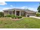 Charming single-story home features a well-manicured lawn, colorful foliage, and a screened garage at 6112 Kinlock Ave, Spring Hill, FL 34608