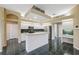 Bright kitchen features white cabinets, stainless appliances, a tiled floor, and a functional island counter at 6112 Kinlock Ave, Spring Hill, FL 34608