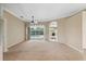 Spacious living room featuring a ceiling fan, neutral carpet, and sliding glass doors to the pool area at 6112 Kinlock Ave, Spring Hill, FL 34608