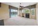 Sun-lit living room with a fireplace, ceiling fan, and access to an outdoor pool area at 6112 Kinlock Ave, Spring Hill, FL 34608