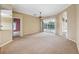 Bright and spacious living room with neutral walls and carpet and sliding glass doors to the outside pool at 6112 Kinlock Ave, Spring Hill, FL 34608