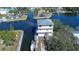 An aerial view showcasing a waterfront home with a boat dock and neighborhood canals at 6801 Nowiki Ave, Hudson, FL 34667