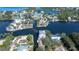 Aerial view showcasing waterfront property with canal access amid lush greenery and surrounding homes at 6801 Nowiki Ave, Hudson, FL 34667