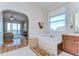 Bright bathroom featuring a soaking tub, vanity, and archway to the bedroom with ocean views at 6801 Nowiki Ave, Hudson, FL 34667