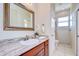 Bright bathroom featuring a granite countertop, decorative mirror, and tiled walk-in shower at 6801 Nowiki Ave, Hudson, FL 34667