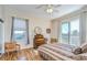 Sunlit bedroom with hardwood floors, a decorative dresser, and a balcony at 6801 Nowiki Ave, Hudson, FL 34667