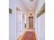 Bright hallway featuring hardwood floors, an elevator, and a colorful area rug at 6801 Nowiki Ave, Hudson, FL 34667