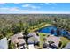 Expansive aerial view of a well-maintained home next to a serene lake and lush green forest at 10910 May Apple Ct, Land O Lakes, FL 34638