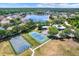 Aerial view featuring community tennis and basketball courts with a beautiful lake in the background at 10910 May Apple Ct, Land O Lakes, FL 34638
