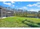 Lush green backyard featuring a screened pool area and serene lake view, perfect for relaxation at 10910 May Apple Ct, Land O Lakes, FL 34638