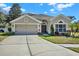 Beautiful single-Gathering home with attached two-car garage, well-maintained lawn, and mature landscaping at 10910 May Apple Ct, Land O Lakes, FL 34638