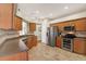 Spacious kitchen features stainless steel appliances, wood cabinets, and tile flooring at 10910 May Apple Ct, Land O Lakes, FL 34638