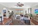 Cozy living room featuring hardwood floors, a ceiling fan, and a view of the screened-in pool area at 10910 May Apple Ct, Land O Lakes, FL 34638