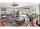 Well lit living room with hardwood floors, a ceiling fan, and a view of the screened-in pool area at 10910 May Apple Ct, Land O Lakes, FL 34638