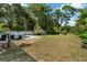 Expansive backyard with lush green grass, mature trees, and a shed, offering ample space and privacy at 1101 N Betty Ln, Clearwater, FL 33755
