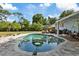 Backyard featuring a sparkling pool, inviting lounge area, and lush landscaping, perfect for entertaining at 1101 N Betty Ln, Clearwater, FL 33755