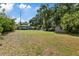 Large backyard showcasing lush greenery, a storage shed, and a cozy patio area, offering space and privacy at 1101 N Betty Ln, Clearwater, FL 33755
