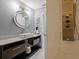 Modern bathroom with a sleek vanity, round mirror with integrated lighting, and a state-of-the-art shower panel system at 1101 N Betty Ln, Clearwater, FL 33755