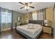 Well-lit bedroom showcases a gray bed frame, dark hardwood floors, and dual windows for ample sunlight at 1101 N Betty Ln, Clearwater, FL 33755