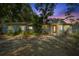 Charming single-story home with a red door, stone accents, well-manicured landscaping, and gravel driveway at 1101 N Betty Ln, Clearwater, FL 33755