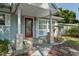 Close-up of a charming covered front porch with stylish stone supports and a decorative red front door at 1101 N Betty Ln, Clearwater, FL 33755