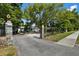 Charming home behind a secure fence, nestled under a large shady tree with lion statues at driveway entrance at 1101 N Betty Ln, Clearwater, FL 33755
