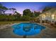 Inviting in-ground pool with stone surround and charming outdoor seating area, perfect for relaxing evenings at 1101 N Betty Ln, Clearwater, FL 33755