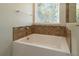 Inviting bathtub with tile accents, creating a serene and stylish bathing experience at 11134 Horned Owl Rd, Weeki Wachee, FL 34614